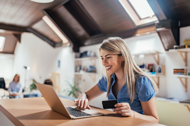 blonde woman sitting at her laptop and smiling